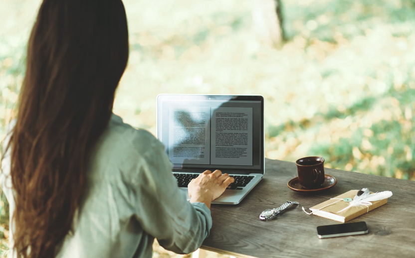 person writing a book on a laptop
