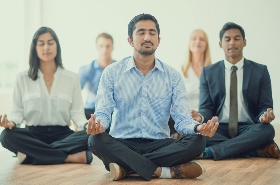 people in business clothing sitting in a meditative pose